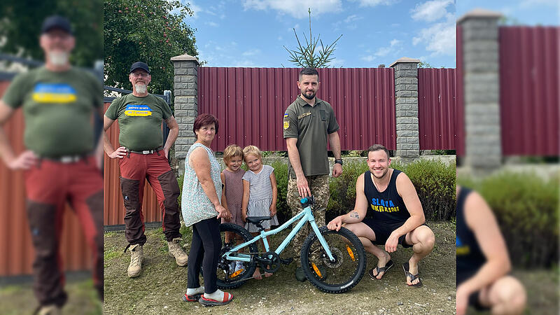 Kinder aus ukrainischen Familien, die ihre Väter an der Front verloren haben, hat Toni Messingschlager (rechts) mit einer Fahrradspende überrascht.
