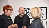 Die beiden Künstler Ingrid Seidel und Bernd Romankiewitz im Gespräch mit einer Ausstellungsbesucherin.