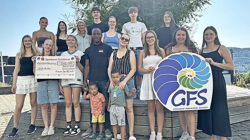 Das P-Seminar „Das GFS hilft" übergibt den Scheck über 15.000 Euro an Janina Möck und ihre Hilfsorganisation.