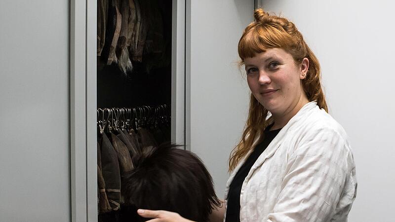 Chefmaskenbildnerin Alicia-Lara M&uuml;ller vor einem der gro&szlig;en Metallschr&auml;nke, in denen der Per&uuml;cken-Schatz des Landestheaters aufbewahrt wird.