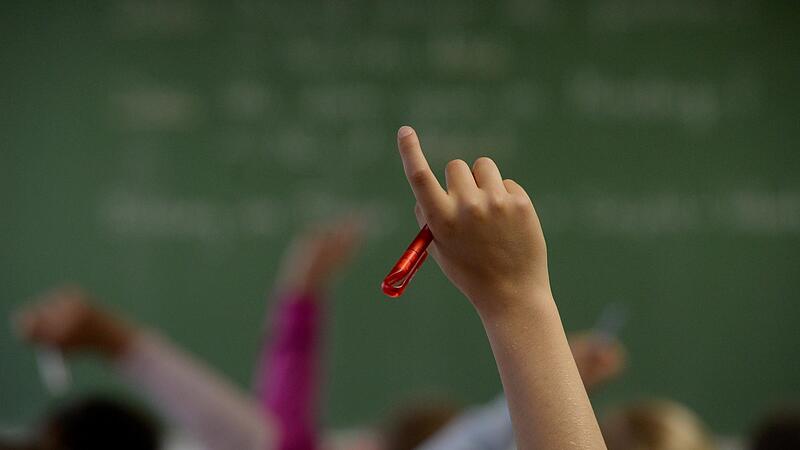 Eine Schülerin meldet sich in einem Klassenzimmer während des Unterrichts.