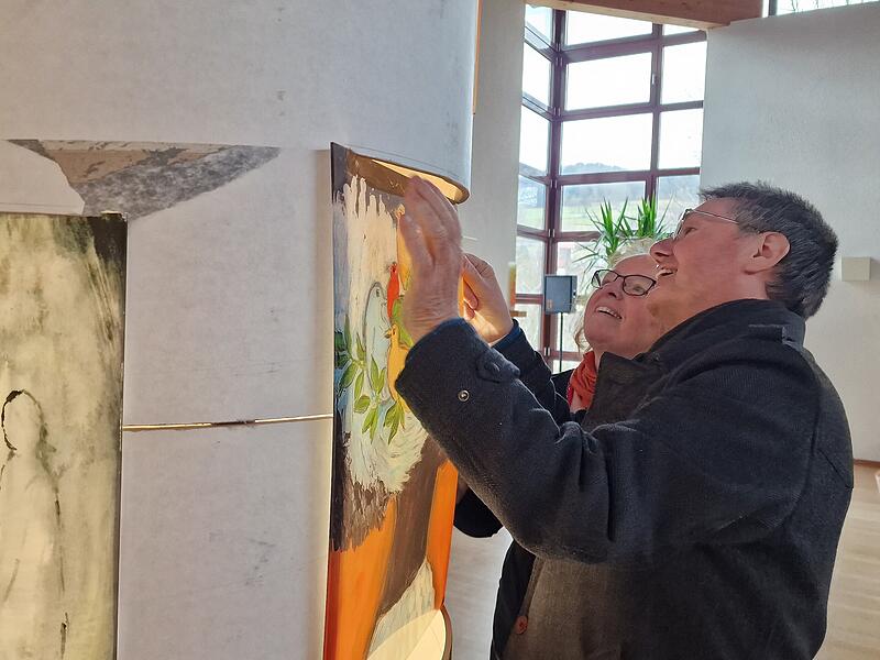 Bernhard und Doris Hopf kontrollieren, dass die Bilder gut sitzen.