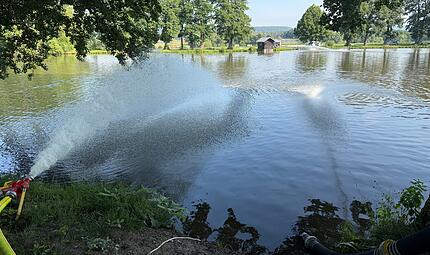 Die Neustadter Feuerwehr spritzt Wasser zurück in einen Teich bei Ketschenbach. Die Fische freuen sich. Die Neustadter Feuerwehr spritzt Wasser zurück in einen Teich bei Ketschenbach. Die Fische freuen sich.