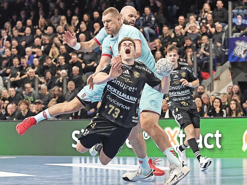 Der Melsunger Dainis Kristopans foult Vigg&oacute; Kristj&aacute;nsson (vorne) vom HC Erlangen am Kreis.
