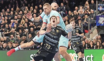 Der Melsunger Dainis Kristopans foult Vigg&oacute; Kristj&aacute;nsson (vorne) vom HC Erlangen am Kreis.