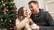 Eine Frau und ein Mann essen Schokolade an Weihnachten