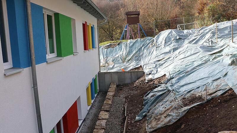 Im Hintergrund mit Folie abgedeckt ist die neue Hangbefestigung zu sehen. Im Vordergrund die Gestaltung der Hangbefestigung an der oberen Seite des Kindergartens mit neu eingebrachter Drainage.Forchheim & Fr&auml;nkische Schweiz