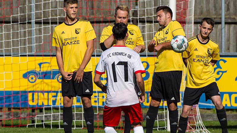 Der Steinwiesener Lucas Hollendonner wehrt den Freisto&szlig; des Kronachers Elias See (wei&szlig;es Trikot) in der Mauer mit angelegtem Arm ab.