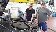 Tobias Hofmann (l.) und Mario Sch&uuml;pferling sehen sich in der Autowerkstatt  in Reifenberg einen Motor an.