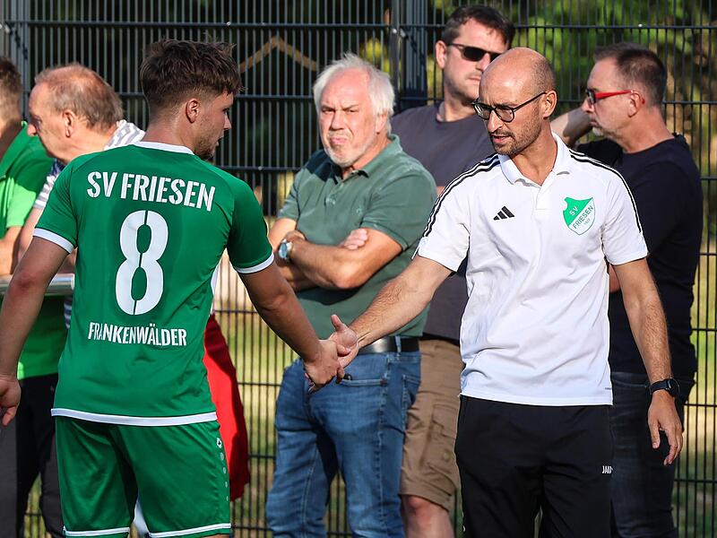 Szene am Rande des Pokalspiels gegen den FC Stockheim: Friesens Trainer Frederic Martin (wei&szlig;) gibt Maximilian T&ouml;pfer die Hand.