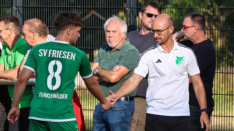 Szene am Rande des Pokalspiels gegen den FC Stockheim: Friesens Trainer Frederic Martin (wei&szlig;) gibt Maximilian T&ouml;pfer die Hand.