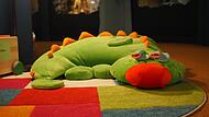 Exponat des Monats im Spielzeugmuseum Neustadt ist der Drache Fridolin, produziert von der Firma Haba. Er scheint schon auf die jungen Leseratten in der Leseecke zu warten.