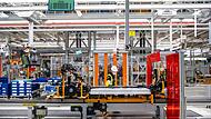 Arbeiter arbeitet mit der Batterie am Unterboden eines E-Autos Arbeiter arbeitet mit der Batterie am Unterboden eines E-Autos