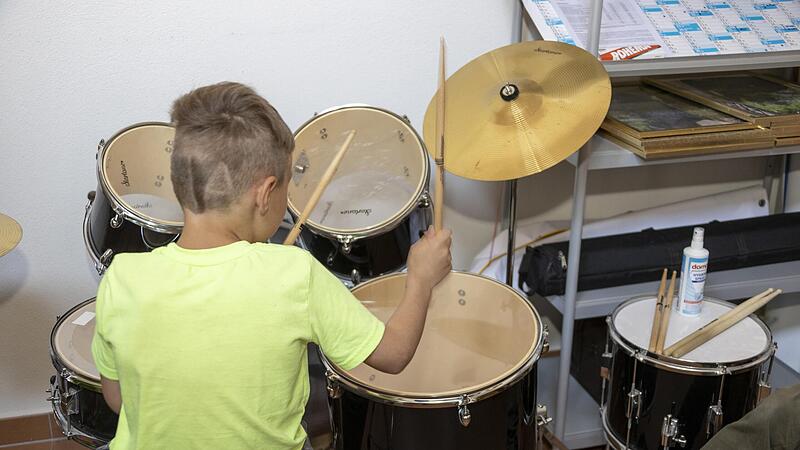 Ein Junge versucht sich am Tag der offenen Tür am Schlagzeug. Ein Junge versucht sich am Tag der offenen Tür am Schlagzeug.