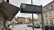 Wer den Plan dafür gemacht hat, ist nicht bekannt: Die neue Anzeigetafel für die Landkreisbusse am Paradeplatz schränkt den Raum für die Markise eines Ladens empfindlich ein.