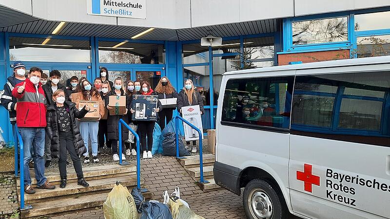 Mitarbeiter der Kleiderkammer des Bayerischen Roten Kreuzes und des Vereins "Freund statt fremd" freuen sich über die Kleiderspenden der Mittelschule Scheßlitz.
