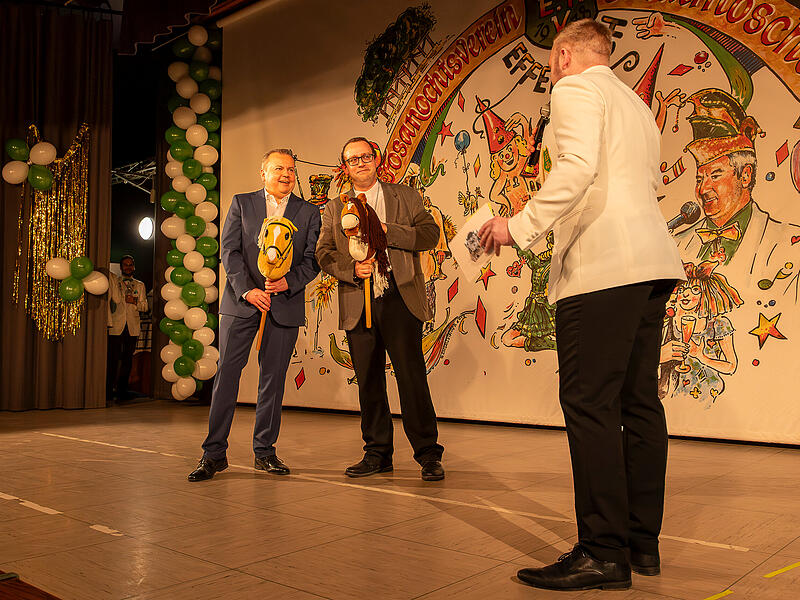B&uuml;rgermeister Peter Lepper (links) und Pfarrvikar Tobias Fehn (Mitte) nahmen von Sitzungspr&auml;sident Jan Leuth&auml;user (rechts) augenzwinkernd das Steckenpferd entgegen &ndash; als kleine Einstimmung auf den n&auml;chsten Georgi-Ritt.