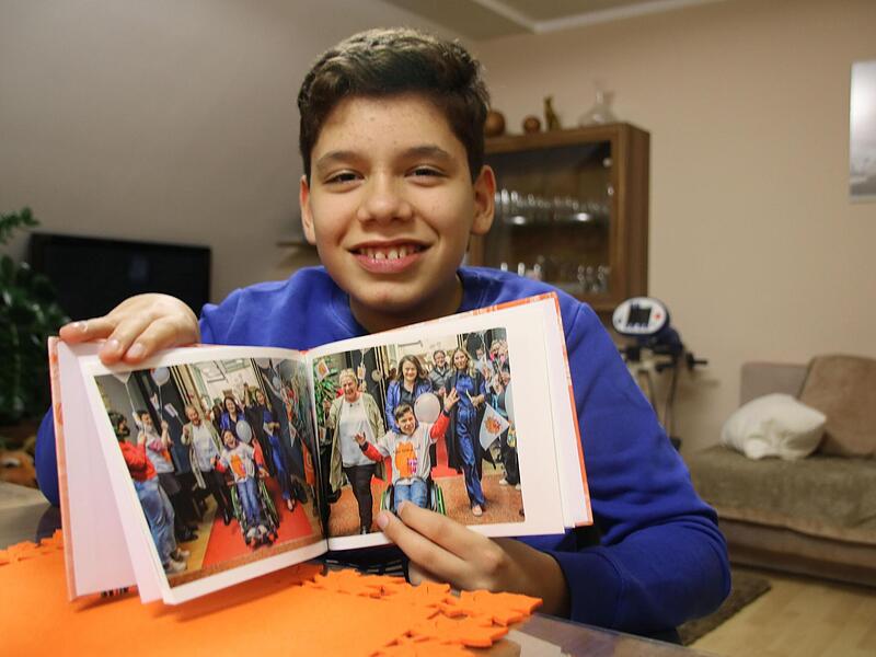 Ein Buch voller schöner Erinnerungen: Rasul hat ein Buch mit Fotos rund um den Kinder-Lebens-Lauf geschenkt bekommen.