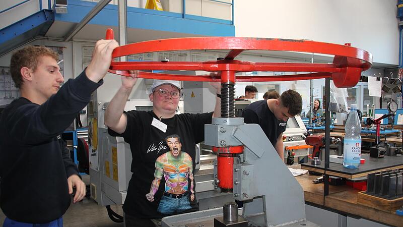 An einer Spindelpresse produzieren Lehrling Bastian Sch&uuml;tz aus Mistelfeld und Sophia Kremer aus Burgkunstadt einen Chip f&uuml;r einen Einkaufswagen.