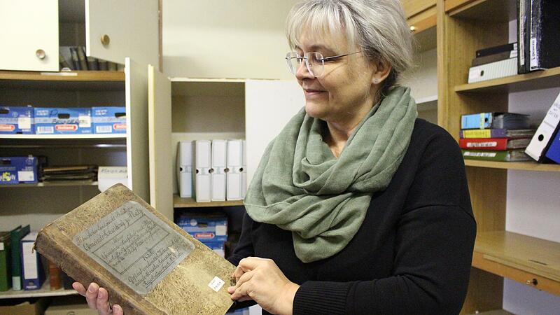 Susanne Karges k&uuml;mmert sich um die Archive der acht Rh&ouml;nallianz-Gemeinden, hier zeigt sie ein altes Buch aus dem Archiv in Geroda.