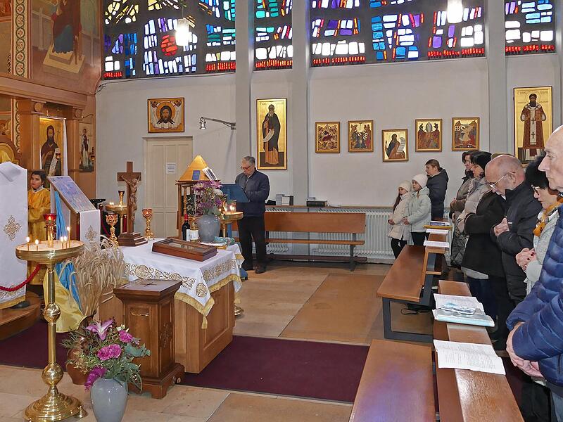 Ukrainer finden in ihrer Kirche in Gaustadt und in Pfarrer Ivan Sokhan (links am Ambo) Halt und St&uuml;tze.
