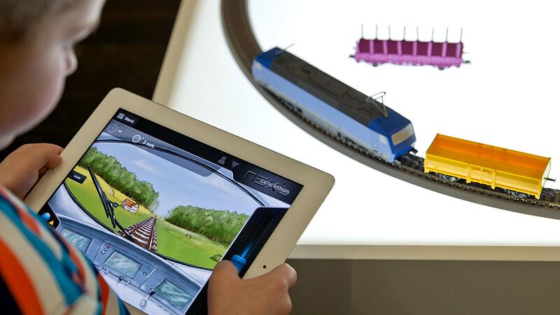 Ein Kind spielt mit einer Modelleisenbahn