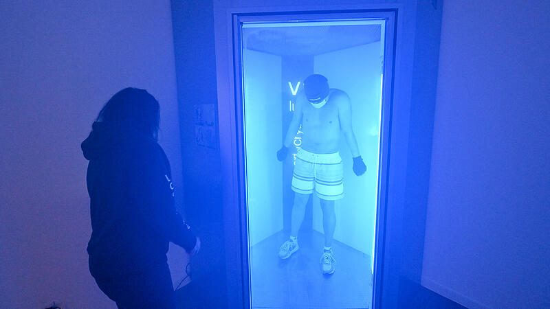 Redakteur Christian Pack beim Selbstversuch in der K&auml;ltekammer Bamberg. Inhaberin Simone Botta beobachtet die Anwendung von au&szlig;en.