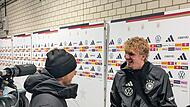 Das war im TV nicht zu sehen: Nick Woltemade scherzt nach Abpfiff und erfolgreicher WM-Qualifikation mit dem Podcaster und Autoren Tommi Schmitt.