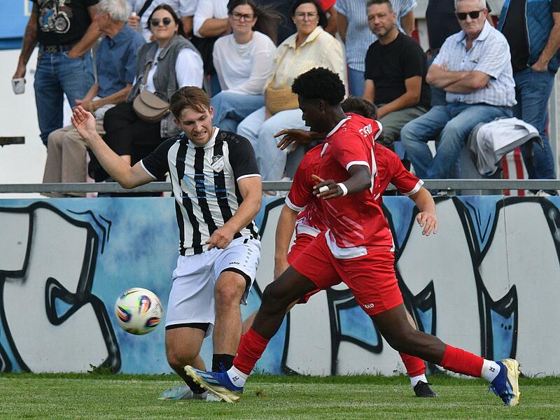 Der Kronacher Youssouf Samoura (rechts) spitzelt den Ball vom Fu&szlig; des Burgkunstadters Julian Willnecker.