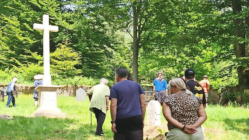 Besucher auf dem Friedhof Altglash&uuml;tten. Im Hintergrund steht das neue Sandsteinkreuz.