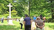 Besucher auf dem Friedhof Altglash&uuml;tten. Im Hintergrund steht das neue Sandsteinkreuz.