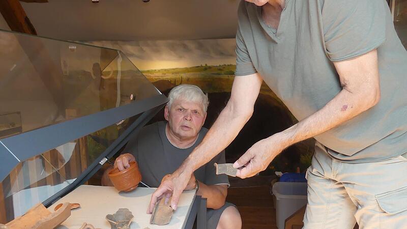 Ottmar V&ouml;llner und Karlheinz Feuerlein (nicht zu sehen) best&uuml;cken eine Vitrine im Heimatmuseum H&ouml;chstadt mit Bestandteilen von Amphoren und terra sigillata, einem Geschirr der Antike.