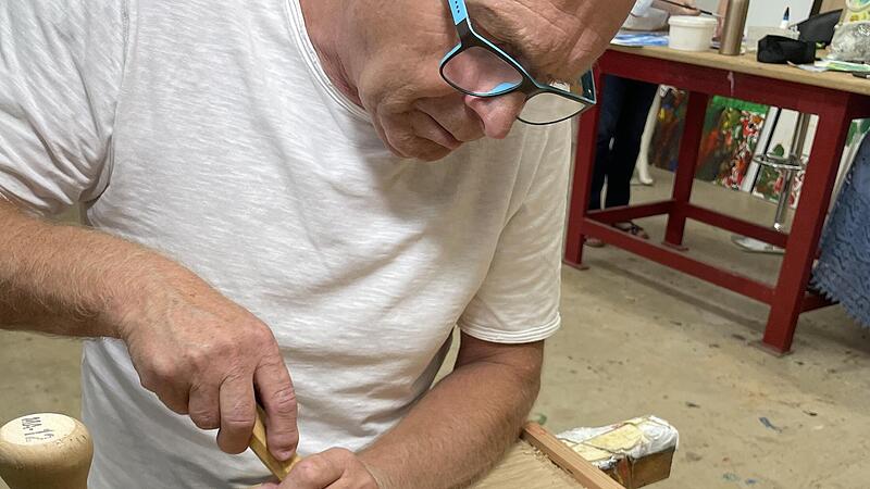 Bernhard G&ouml;&szlig;mann-Schmitt bringt Schnitzereien an der neuen Backhausbank an.