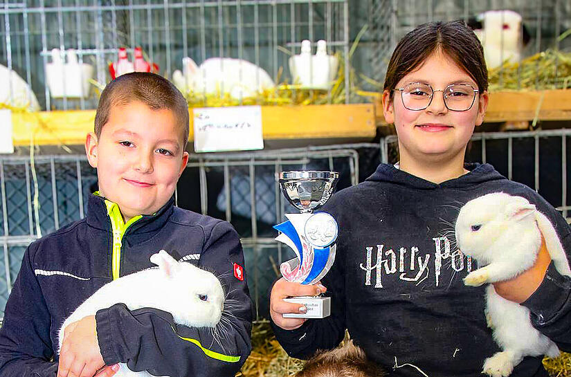 Toni Holzheid und Vroni Holzheid und ihr kleiner Bruder sind stolz auf ihre Kaninchen. Sie stellten die beste Zuchtgruppe im Jugendbereich und erhielten einen Pokal.