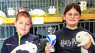 Toni Holzheid und Vroni Holzheid und ihr kleiner Bruder sind stolz auf ihre Kaninchen. Sie stellten die beste Zuchtgruppe im Jugendbereich und erhielten einen Pokal.