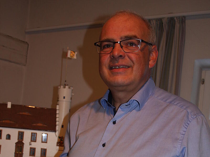 B&uuml;rgermeister Hanng&ouml;rg Zimmermann pr&auml;sentiert das neue Buch &bdquo;Heimatbote G&ouml;&szlig;weinstein&ldquo; vor dem Burgmodell im &bdquo;Haus des Gastes&ldquo;.