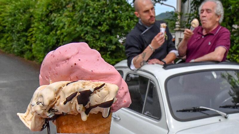 Giuseppe Presti (rechts) und Mitarbeiter Alex schlecken vor dem Betriebsgebäude in Ebermannstadt Eis – selbst gemacht aus ihren Zutaten.Forchheim & Fränkische Schweiz