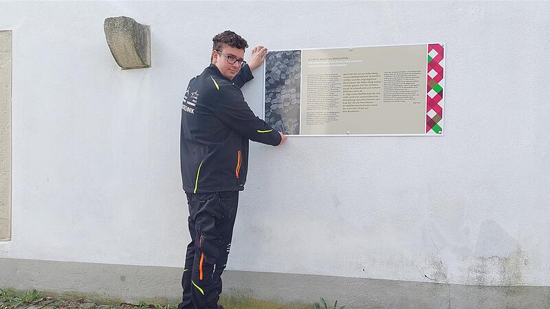 Bundesfreiwilligendienstleistender Bastian Brückner vom Volkersberg-Team montiert die neue Informationstafel.