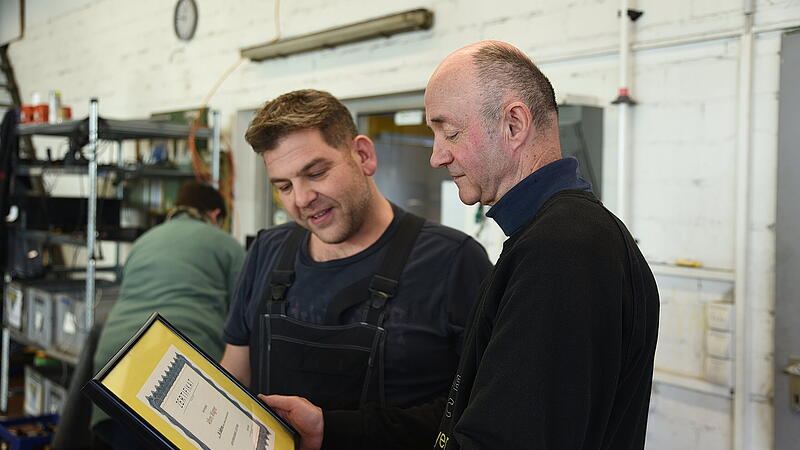 Juniorchef Peter Bayer (l.) &uuml;berreicht Alfons Wagner das Zertifikat f&uuml;r 50 Jahre Zugeh&ouml;rigkeit zum selben Betrieb in Effeltrich.