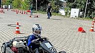 Kinder beim Kart fahren.