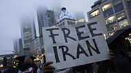 Mit Schildern und Flaggen demonstrierten Teilnehmer einer Kundgebung in Frankfurt gegen das Regime im Iran.
