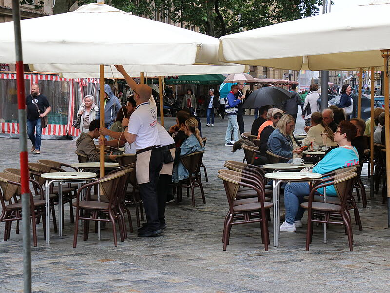 Am Grünen Markt sind die Sitzplätze trotz Nieselregens gut besucht. Am Grünen Markt sind die Sitzplätze trotz Nieselregens gut besucht.