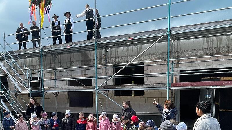 Beim Richtfest führen neuen Kindergarten durften die Kinder nicht fehlen, die hier ihr Lied von den „fleißigen Handwerkern“ schmettern. Zum Dank gab’s einen Bonbonregen.