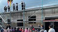 Beim Richtfest führen neuen Kindergarten durften die Kinder nicht fehlen, die hier ihr Lied von den „fleißigen Handwerkern“ schmettern. Zum Dank gab’s einen Bonbonregen.