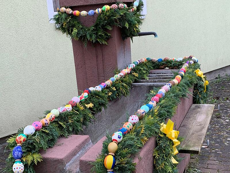 Osterbrunnen in Kleinbrach: einige Mädchen haben die Eier bemalt und Frauen haben die Girlanden gebunden