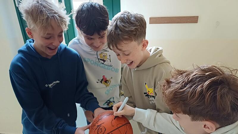 Schüler bemalen Ball, um einen Mitschüler zu mobben Mobbing kann auf den ersten Blick ganz harmlos beginnen - wie in der hier nachgestellten Szene mit dem Bemalen eines Balls.
