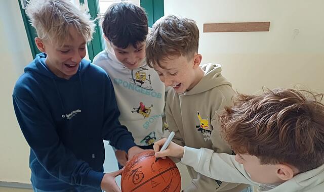 Schüler bemalen Ball, um einen Mitschüler zu mobben Mobbing kann auf den ersten Blick ganz harmlos beginnen - wie in der hier nachgestellten Szene mit dem Bemalen eines Balls.