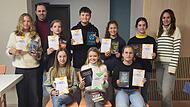 Alle Mitwirkenden des Vorlesewettbewerbs, darunter die Siegerin Antonia Lauter (vorne Mitte), die Lehrkraft Anna Schäfer (rechts) und Schulleiter Markus Binzenhöfer (zweiter von links hinten).