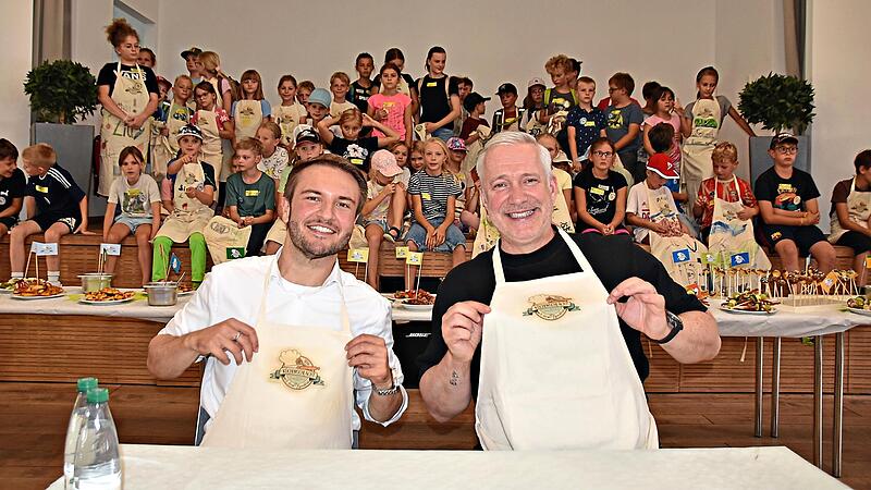 Nicht nur die Kinder hatten viel Spaß an der Aktion: Landrat Jonas Gleich und Sternekoch Alexander Herrmann signierten Schürzen und erhielten als Dank jeweils eine Schürze, auf der alle Kinder unterschrieben hatten Nicht nur die Kinder hatten viel Spaß an der Aktion: Landrat Jonas Gleich und Sternekoch Alexander Herrmann signierten Schürzen und erhielten als Dank jeweils eine Schürze, auf der alle Kinder unterschrieben hatten