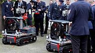 Feuerwehrleute begutachten in Baiersdorf die neuen L&ouml;schroboter.
